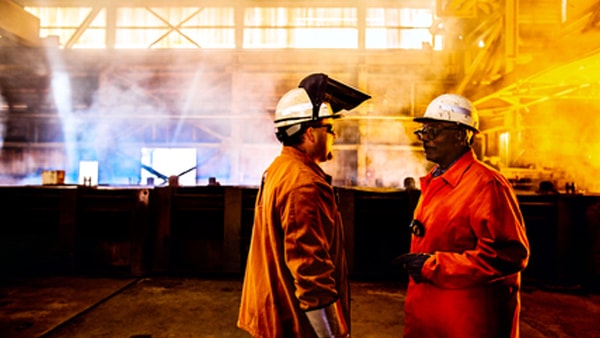 Two industrial workers in smoky environment