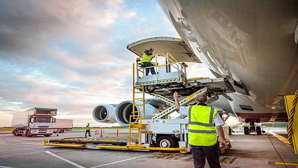 Airport ground crew loading luggage onto an airplane