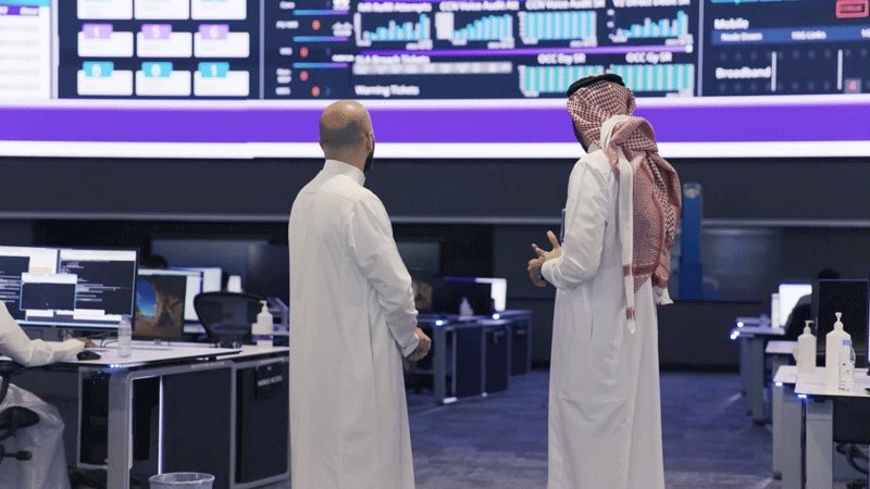 Saudi Telecom employees discussing work 