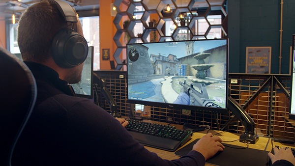 Man with headset plays video game